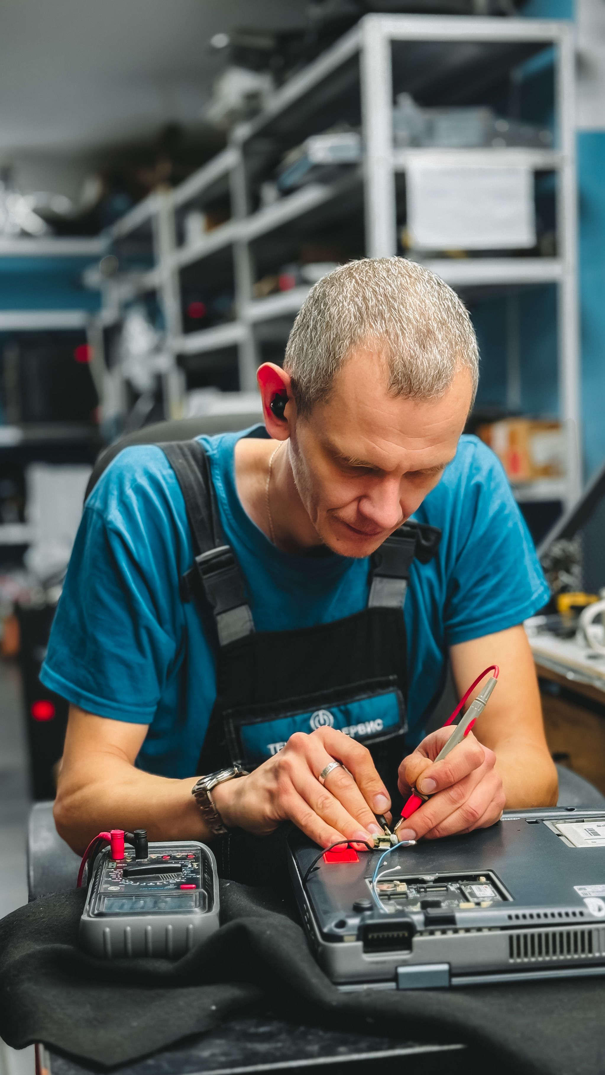 Technician repairing a laptop in a workshop